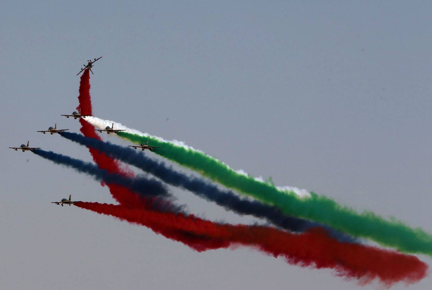 Performance by Al Fursan, the aerobatics demonstration team of the UAE Air Force, is seen behind a Qatar Airways plane at the Dubai Airshow.  (Picture courtesy: AFP/Marwan Naamani)