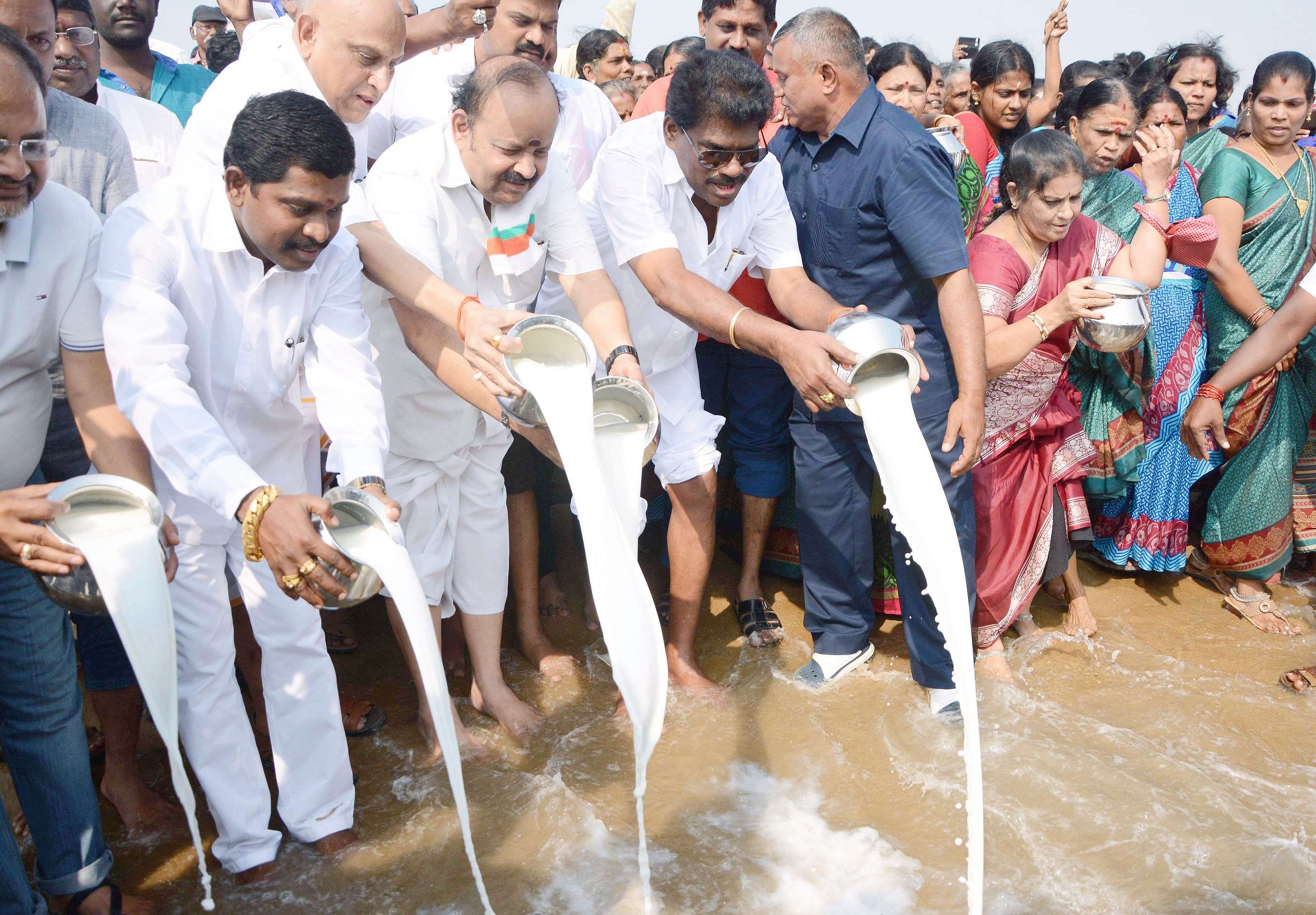 Indian people pour milk into the sea as an offering during a ceremony for the victims of the 2004 earthquake and tsunami at Marina Beach in Chennai on december 26, 2015. The earthquake and tsunami which struck the Indian Ocean on December 26, 2004 killed over 230,000 people and devastated coastal communities. AFP PHOTO / STR