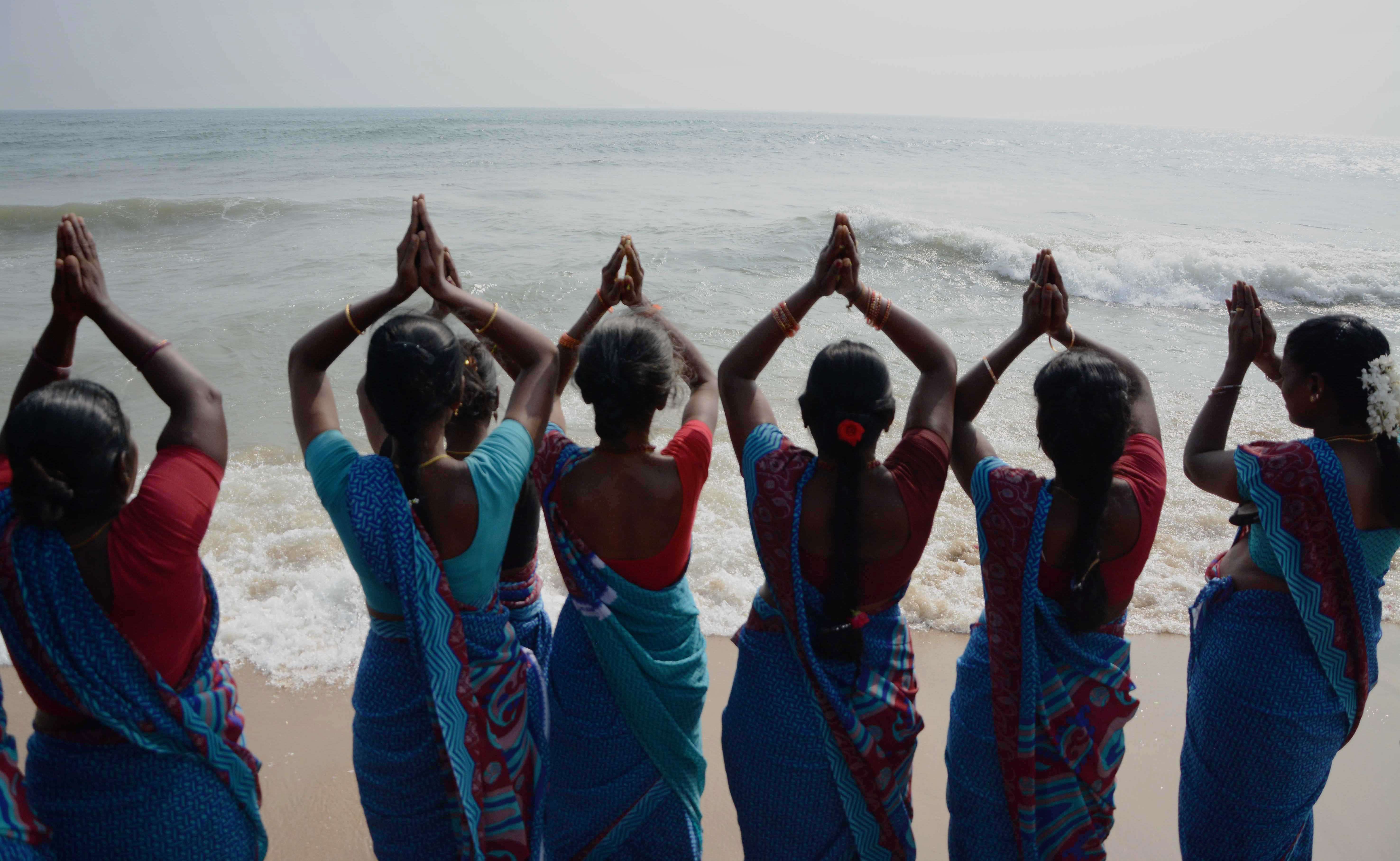 Indian women offer prayers during a ceremony for the victims of the 2004 earthquake and tsunami at Marina Beach in Chennai on december 26, 2015. The earthquake and tsunami which struck the Indian Ocean on December 26, 2004 killed over 230,000 people and devastated coastal communities. AFP PHOTO / STR