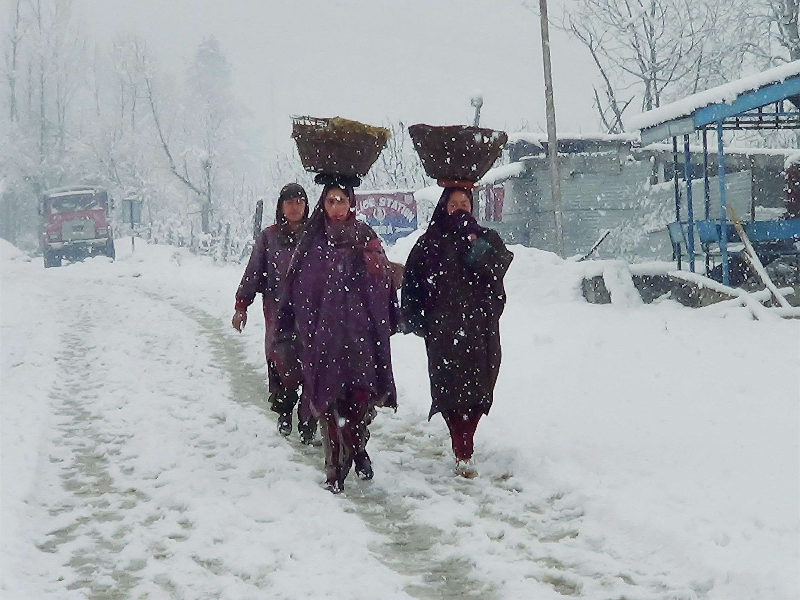 Kashmiri women walk on the snow-covered Mugal Road near Pir Panjal ranges in Shopian. (Photo courtesy: PTI)