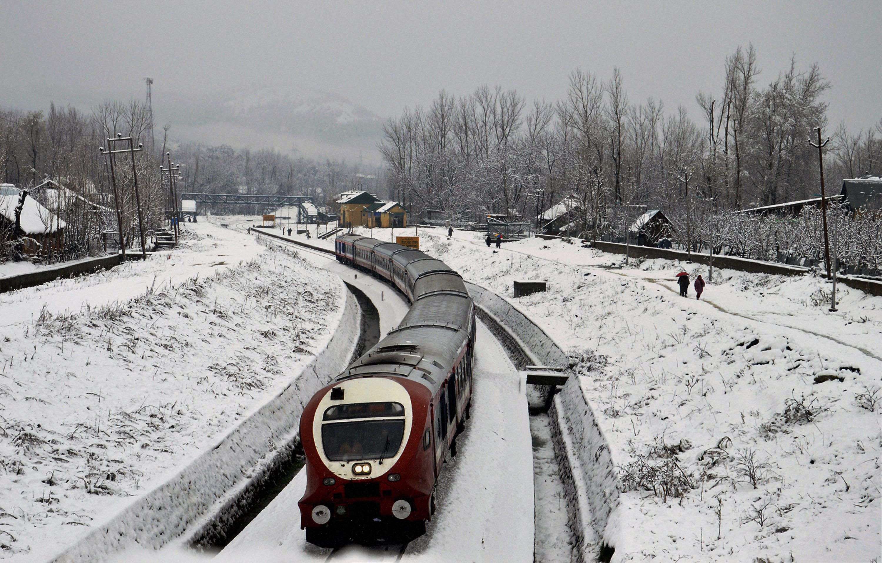Anantnag: A train moves on snow covered railway tracks after season's first snowfall, in Anantnag district of south Kashmir. (Photo courtesy: PTI)