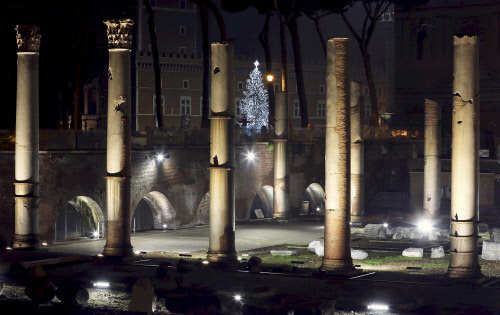 A Christmas tree seen through ancient ruins in downtown Rome, Italy (Photo Courtesy: Stefano Rellandini / Reuters)