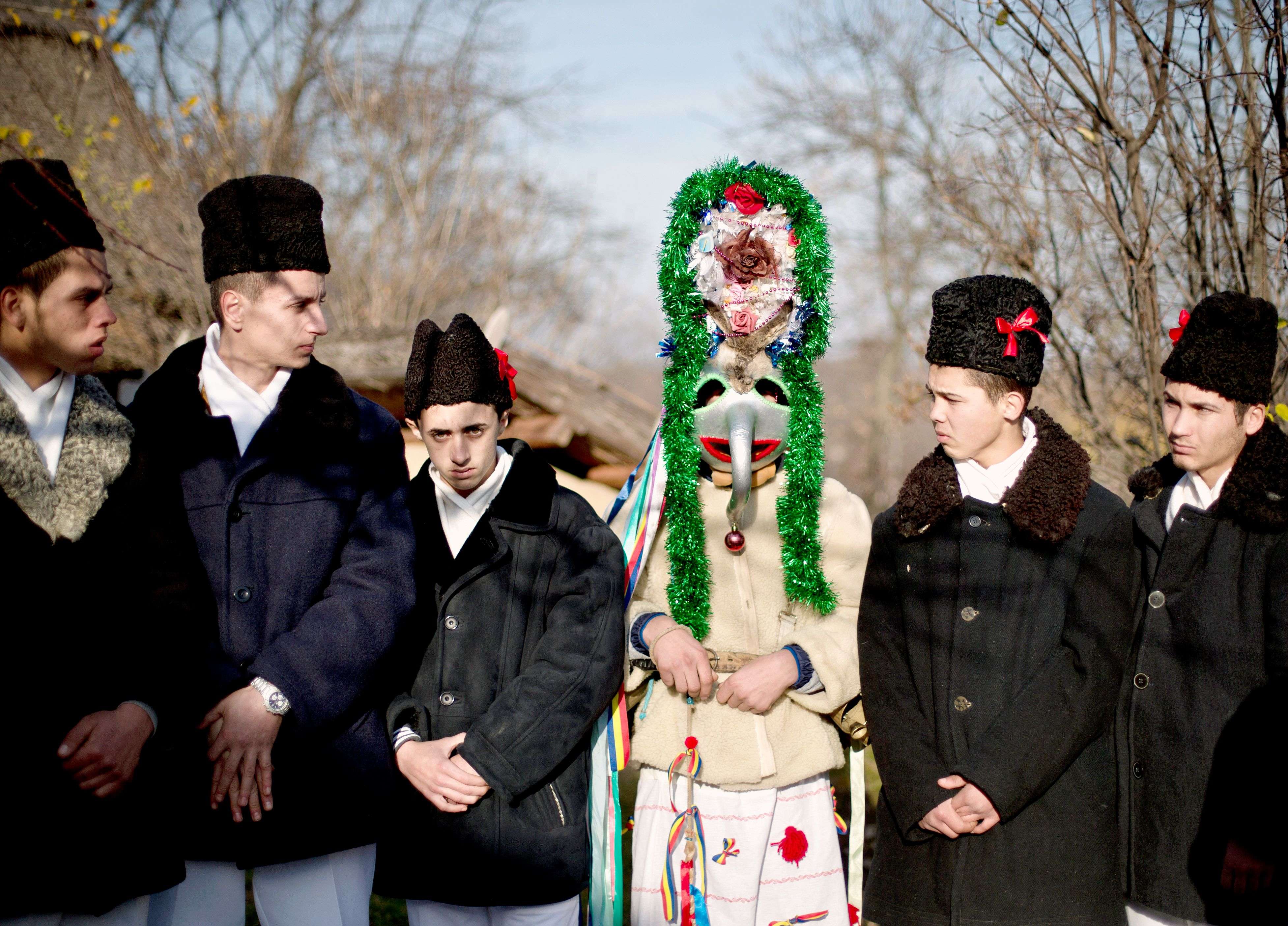 Men wearing traditional Romanian costumes, masks and animal furs prepare to perform in a show of winter traditions at the Village Museum in Bucharest, Romania, Sunday, Dec. 13, 2015. In pre-Christian rural traditions, dancers wearing colored costumes or animal furs toured from house to house in villages, singing and dancing to ward off evil. (AP Photo/Vadim Ghirda)
