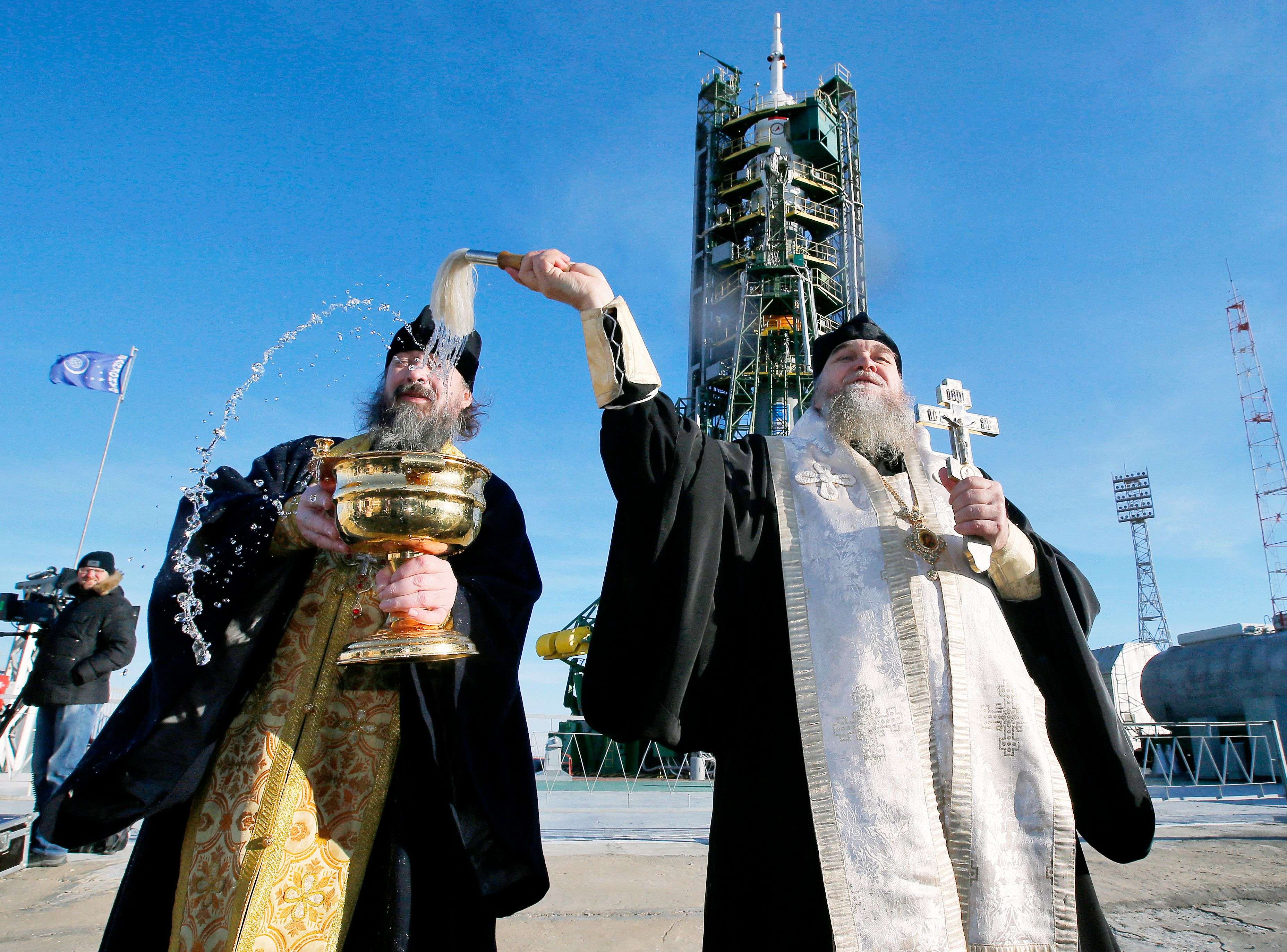 Orthodox priests conduct a blessing service in front of the Soyuz TMA-19M spacecraft at Russian leased Baikonur cosmodrome, Kazakhstan, Monday, Dec. 14, 2015.  The new Soyuz mission is scheduled to start on Tuesday, Dec. 15. The Russian rocket will carry U.S. astronaut Tim Kopra, Russian cosmonaut Yuri Malenchenko and British astronaut Tim Peake. (AP Photo/Dmitry Lovetsky)