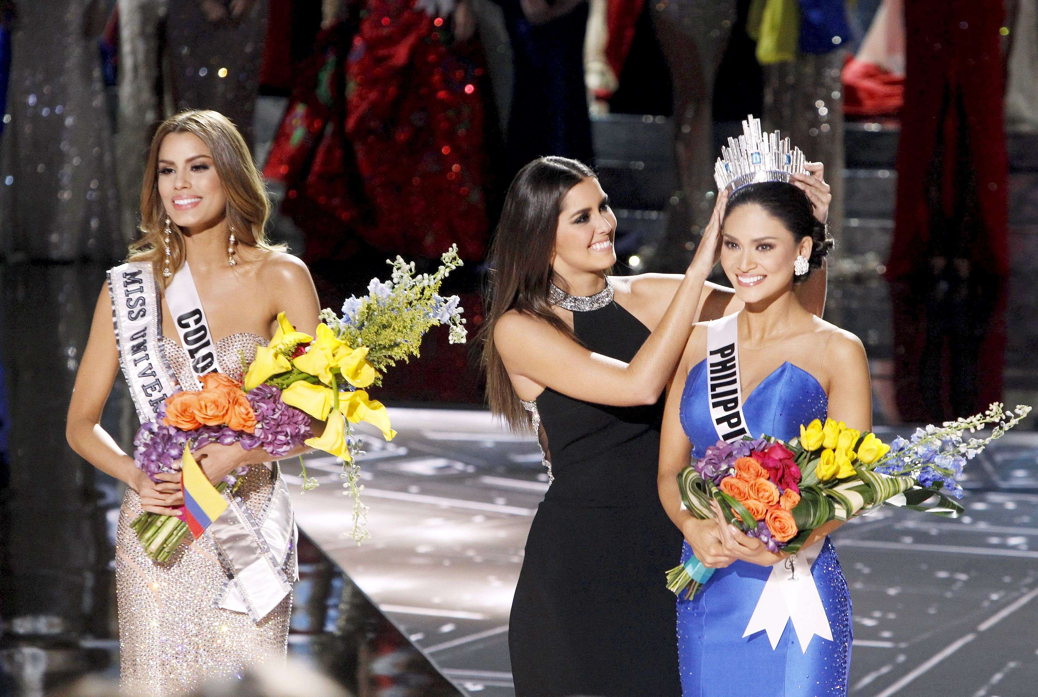 Miss Colombia Ariadna Gutierrez (L) stands by as Miss Universe 2014 Paulina Vega (C) transfers the crown to winner Miss Philippines Pia Alonzo Wurtzbach during the 2015 Miss Universe Pageant in Las Vegas, Nevada, December 20, 2015. Miss Colombia was originally announced as the winner but the host Steve Harvey said he made a mistake when reading the card. REUTERS/Steve Marcus ATTENTION EDITORS - FOR EDITORIAL USE ONLY. NOT FOR SALE FOR MARKETING OR ADVERTISING CAMPAIGNS