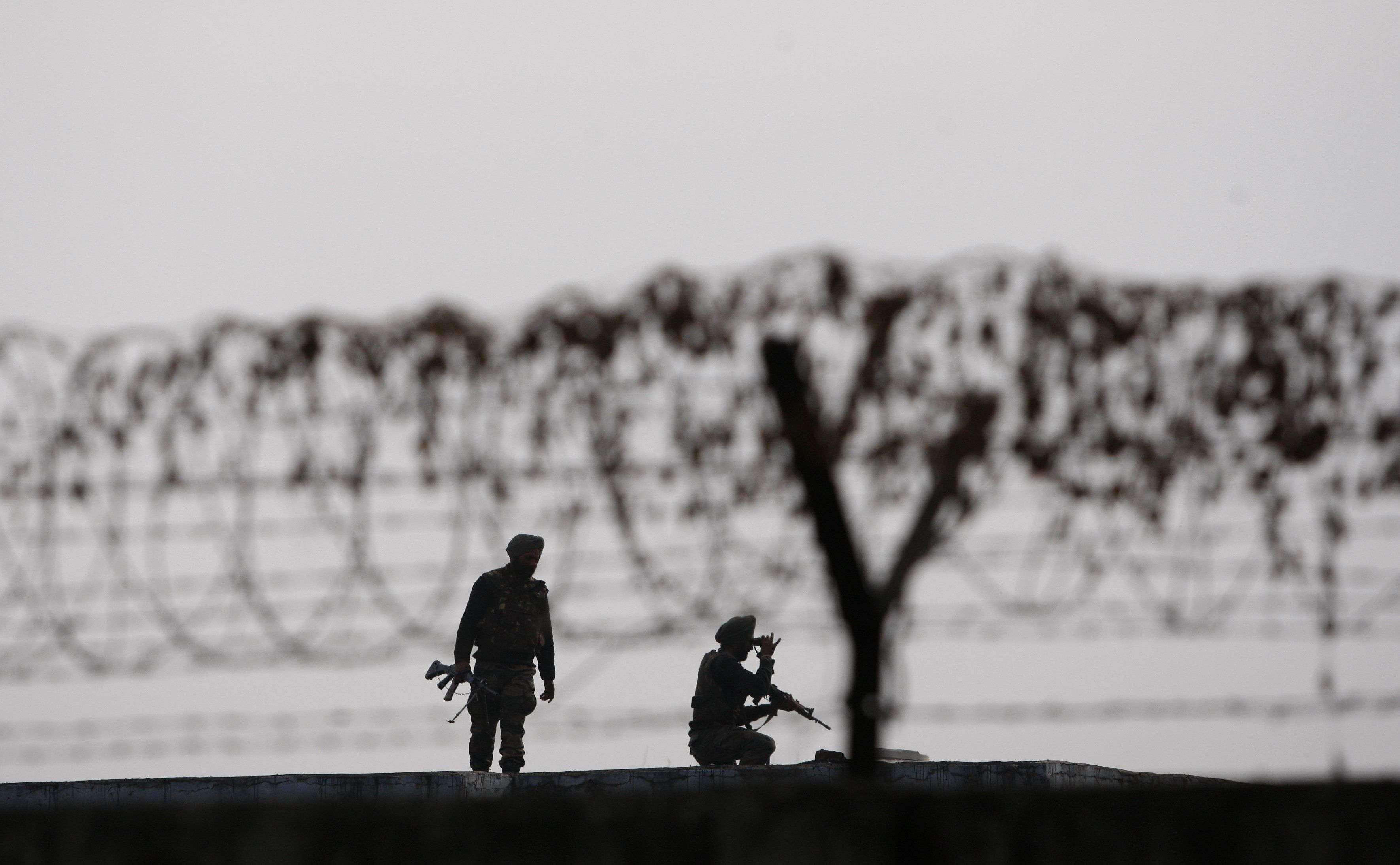 Indian soldiers keep guard at the perimeter fence of the Indian air force base in Pathankot, India, Wednesday, Jan. 6, 2016.  Indian defense minister Manohar Parrikar had said on Tuesday that Indian forces have killed the last of the six militants who attacked the air force base near the Pakistan border over the weekend, though soldiers are still searching the base as a precaution. (AP Photo/Channi Anand)