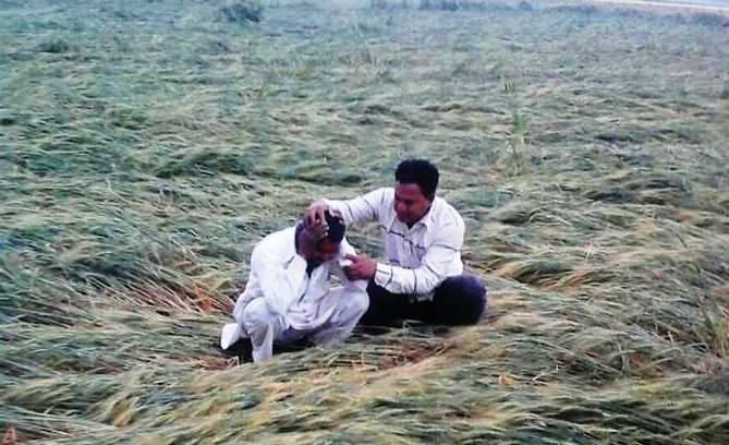A farmer, whose wheat crop was damaged due to rain and hailstorm, being consoled by a fellow farmer at a village in Jalore on Saturday (Photo- TOI)