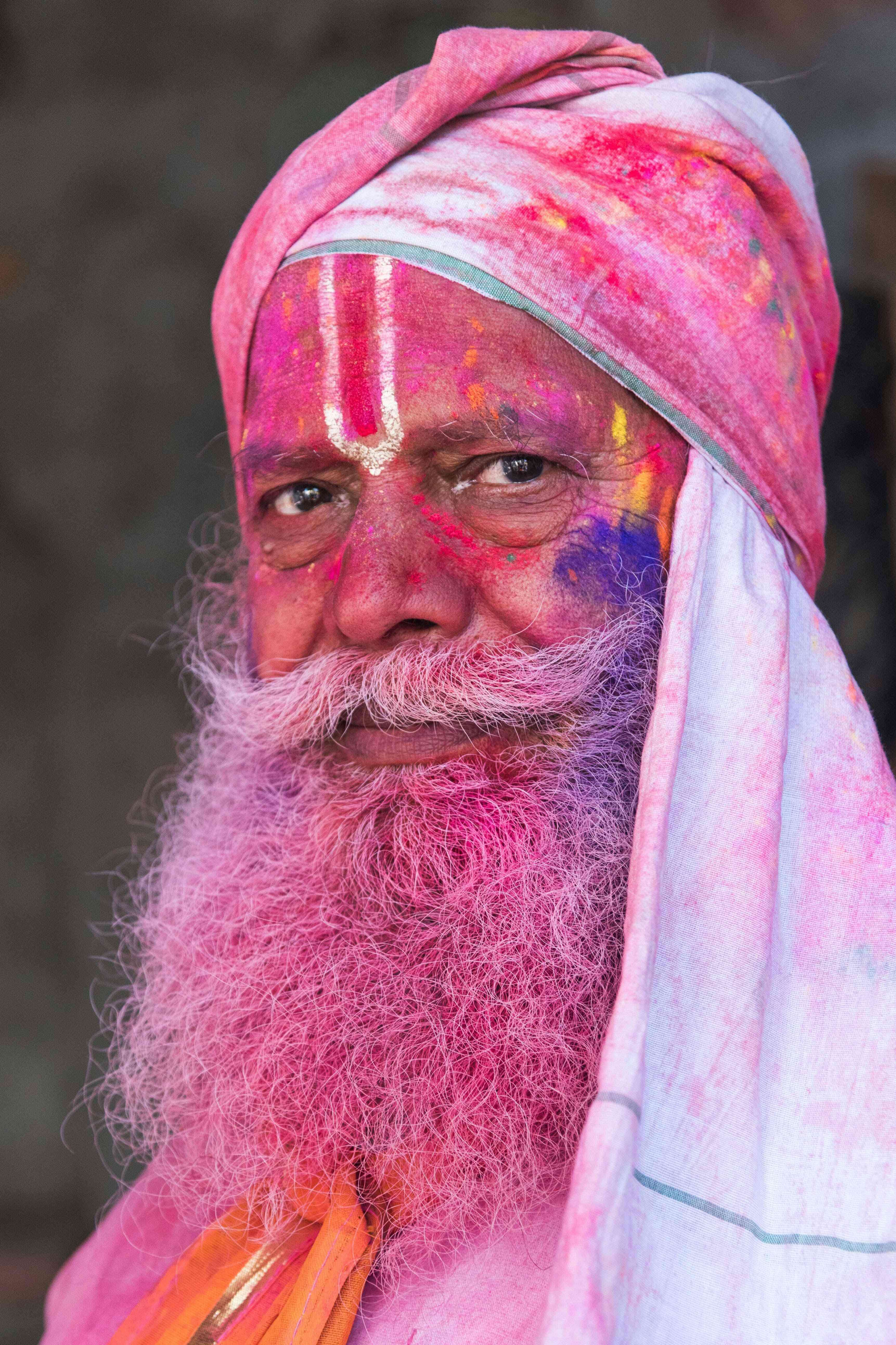 An Indian villager is smeared with colour powder during the Lathmar Holi festival at the Radha Rani temple in Barsana, some 130kms from New Delhi on March 16, 2016.  During the Lathmar Holi festival, the women of Barsana, the legendary hometown of Radha, consort of Hindu God Krishna, attack the men from Nandgaon, the hometown of Hindu God Krishna, with wooden sticks in response to their efforts to put color on them. / AFP PHOTO / François Xavier MARIT