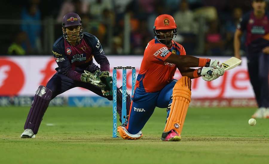 Gujarat Lions Dwayne Smith (R) watched by Rising Pune Supergiants captain Mahendra Singh Dhoni plays a shot during the 2016 Indian Premier League(IPL) Twenty20 cricket match between Rising Pune Supergiants and Gujarat Lions at The Maharashtra Cricket Association Stadium in Pune on April 29, 2016.   / AFP PHOTO / INDRANIL MUKHERJEE