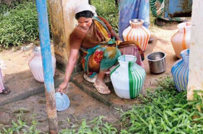 A woman scoops out water from a puddle created due to a leak in a water tank in Ramanathapuram. Water scarcity is the overriding problem in the district