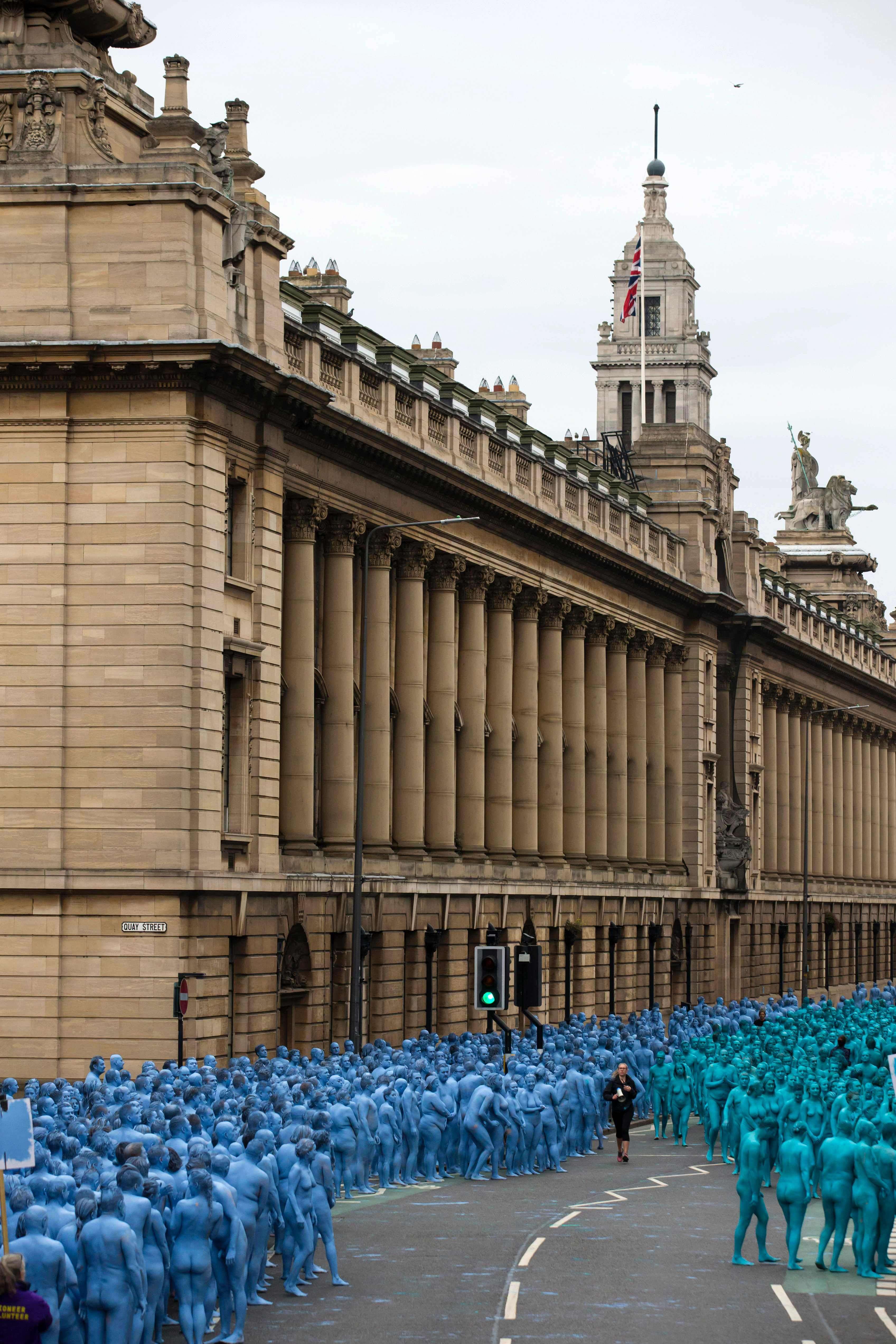 Naked volunteers, painted in blue to reflect the colours found in Marine paintings in Hull's Ferens Art Gallery, prepare to participate in US artist, Spencer Tunick's "Sea of Hull" installation in Kingston upon Hull on July 9, 2016. Over a period of 20 years, the New York based artist has created over 90 art installations in some of the most culturally significant places and landmarks around the world including the Sydney Opera House, Place des Arts in Montreal, Mexico City, Ernest Happel Stadium in Vienna and Munich in Germany. / AFP PHOTO / JON SUPER / RESTRICTED TO EDITORIAL USE - MANDATORY MENTION OF THE ARTIST UPON PUBLICATION - TO ILLUSTRATE THE EVENT AS SPECIFIED IN THE CAPTION - NO CLOSE UP SHOTS TO BE REPRODUCED OF INDIVIDUALS INVOLVED IN THE INSTALLATION
