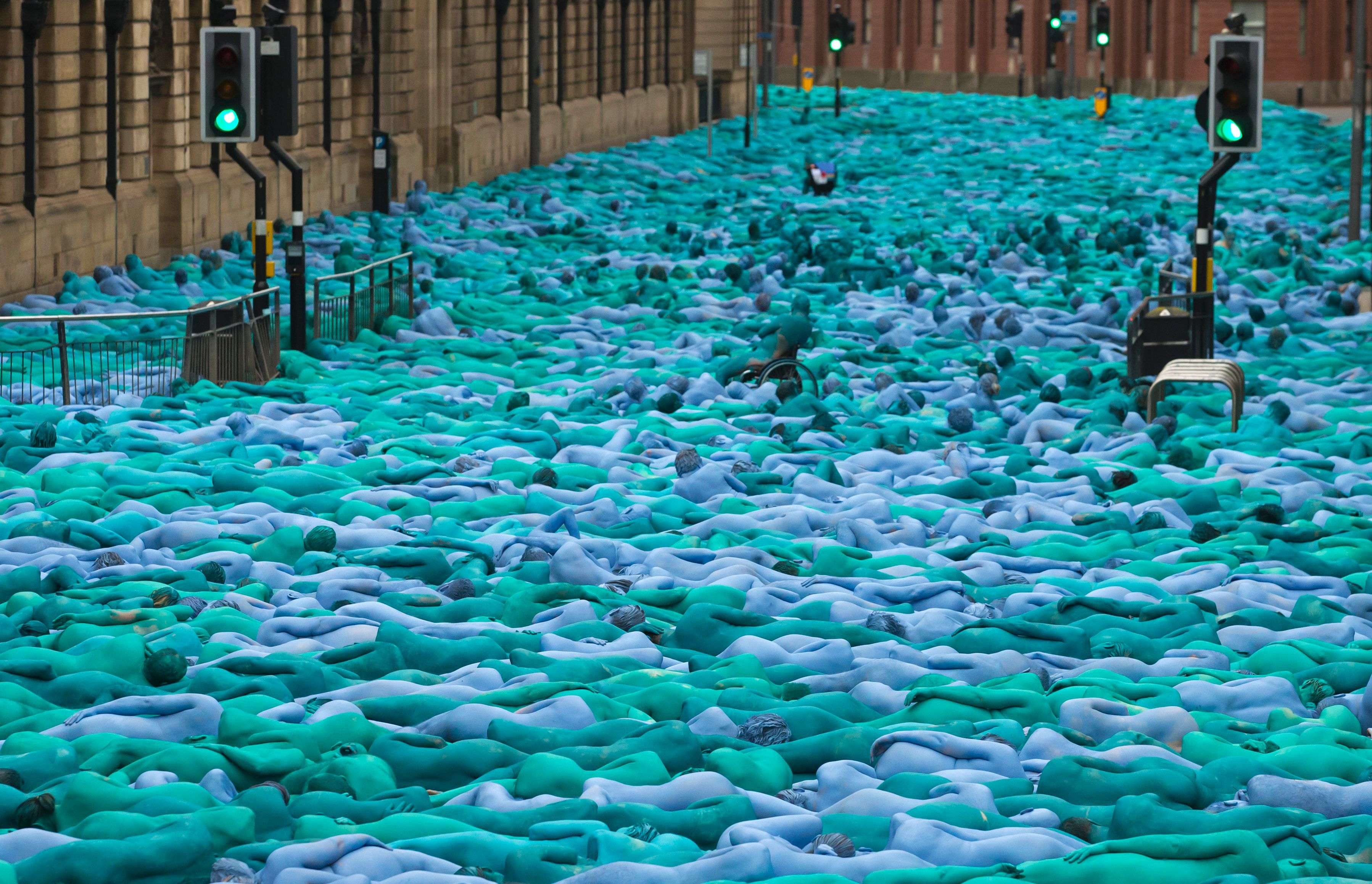 Naked volunteers, painted in blue to reflect the colours found in Marine paintings in Hull's Ferens Art Gallery, participate in US artist, Spencer Tunick's "Sea of Hull" installation in Kingston upon Hull on July 9, 2016. Over a period of 20 years, the New York based artist has created over 90 art installations in some of the most culturally significant places and landmarks around the world including the Sydney Opera House, Place des Arts in Montreal, Mexico City, Ernest Happel Stadium in Vienna and Munich in Germany. / AFP PHOTO / JON SUPER / RESTRICTED TO EDITORIAL USE - MANDATORY MENTION OF THE ARTIST UPON PUBLICATION - TO ILLUSTRATE THE EVENT AS SPECIFIED IN THE CAPTION - NO CLOSE UP SHOTS TO BE REPRODUCED OF INDIVIDUALS INVOLVED IN THE INSTALLATION
