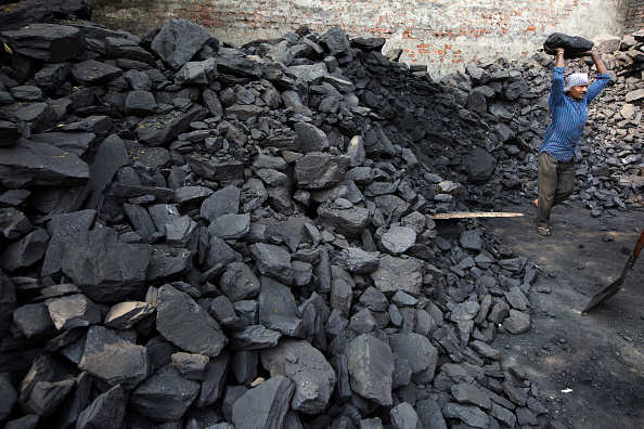 A worker lifts a lump of coal while loading a truck at a wholesaler in New Delhi, India, on Wednesday, Nov. 5, 2014. Prime Minister Narendra Modi is seeking to end a four-decade-old government monopoly on mining and selling coal. Photographer: Kuni Takahashi/Bloomberg via Getty Images