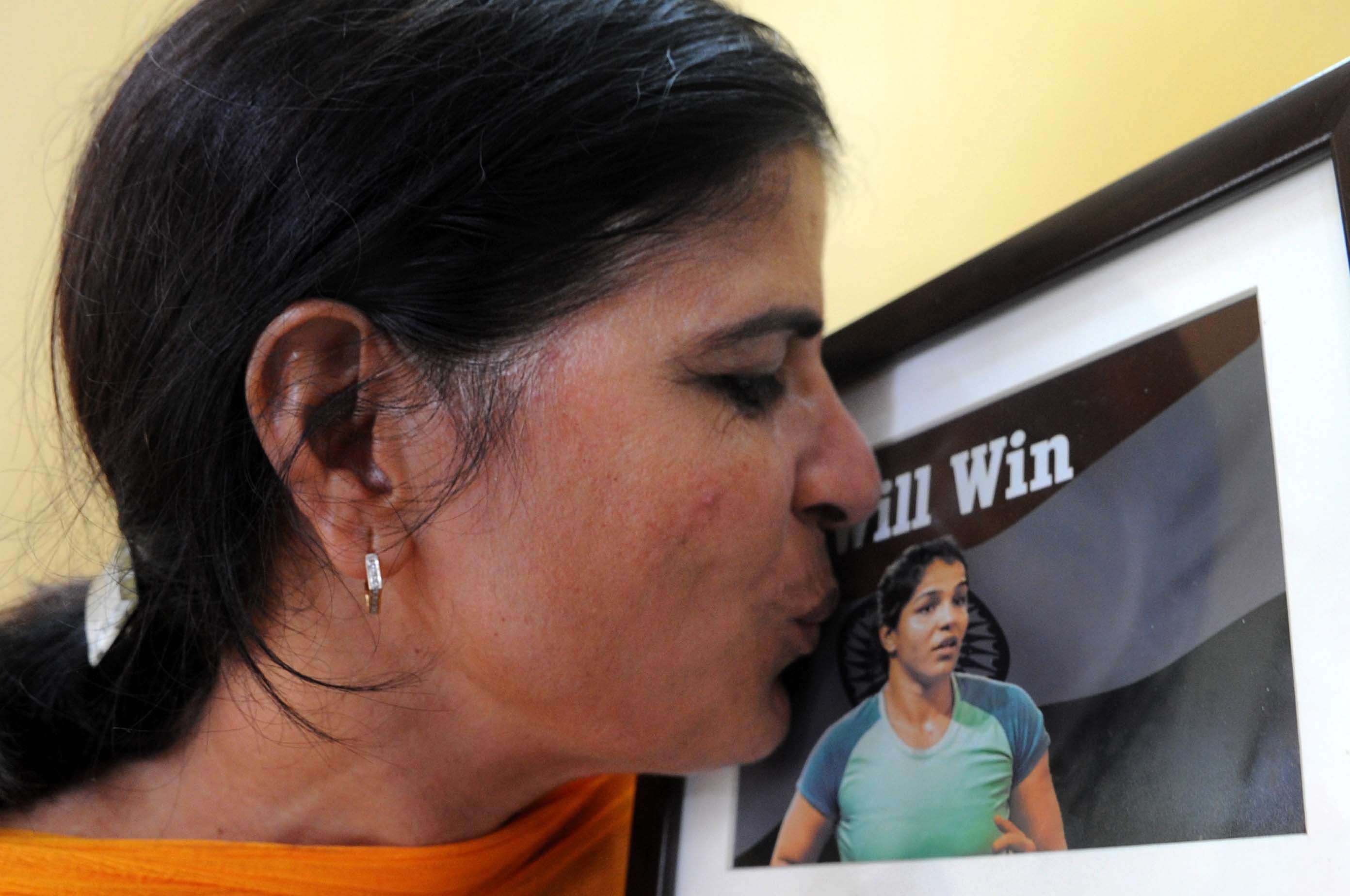 Sudesh,mother of Sakshi kisses her daughter's photo at their residence at Rohtak ,Haryana (approx 77 K.M)after wrestler Sakshi Malik ended India's painful wait for a medal at the Rio Olympic Games by clinching the bronze in the 58kg category.---------PIC BY ANINDYA CHATTOPADHYAY