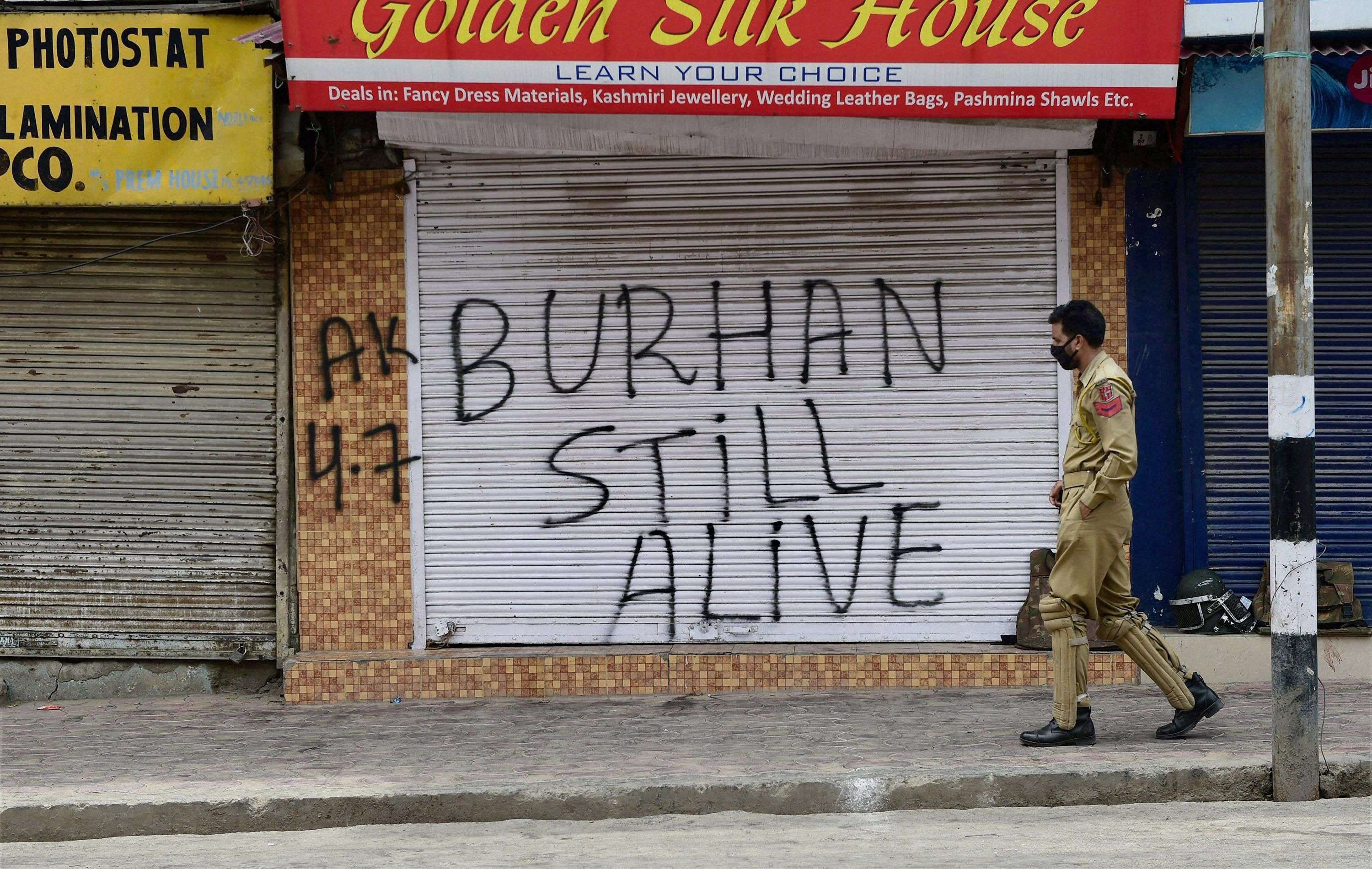 Srinagar: A policeman walks out side closed shops during restriction and strike on Fourth consecutive day  in Srinagar on Monday. Authorities imposed restrictions in most parts of Valley following the killing of most wanted Hizbul Mujahideen commander, Burhan Muzaffar Wani, along with his two associates. PTI Photo by S Irfan (PTI7_12_2016_000042A)
