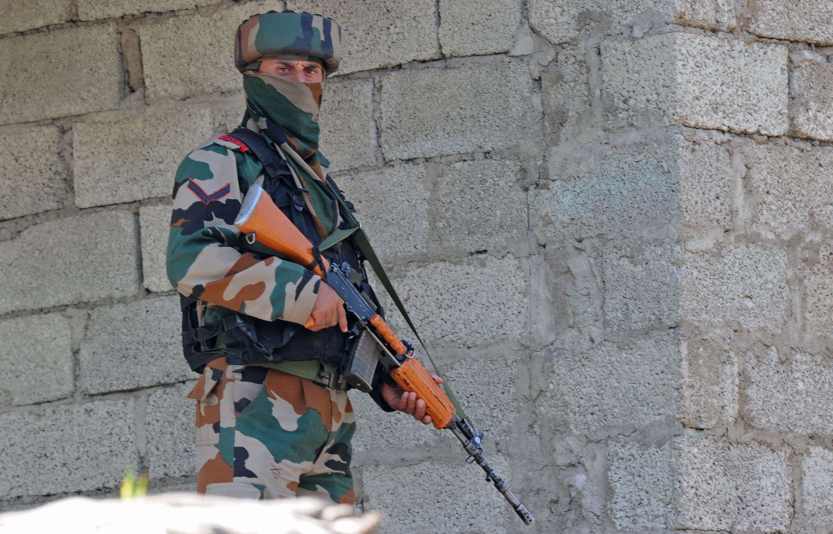 An Indian army soldier takes up a position near the site of a gunbattle between Indian army soldiers and rebels inside an army brigade headquarters near the border with Pakistan, known as the Line of Control (LoC), in Uri on September 18, 2016. Militants armed with guns and grenades killed 17 soldiers in a raid September 18 on an army base in Indian-administered Kashmir, the worst such attack for more than a decade in the disputed Himalayan region. / AFP PHOTO / TAUSEEF MUSTAFA