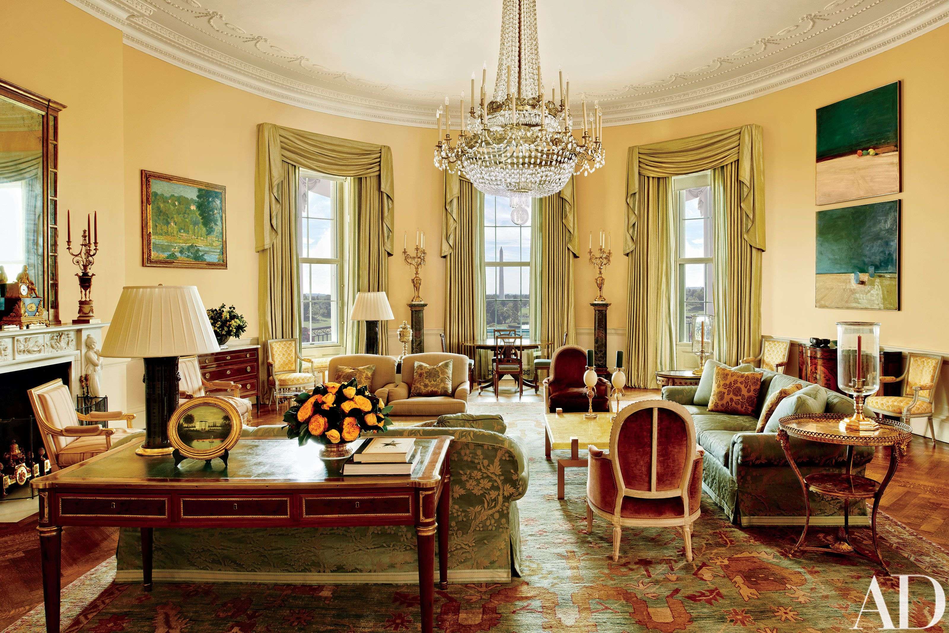 This image provided by Architectural Digest shows the Yellow Oval Room in the White House. Designer Michael S. Smith specified a Donald Kaufman paint for the Yellow Oval Room. Artworks by Paul Cézanne and Daniel Garber flank the mantel. Smith mellowed the Yellow Oval Room with smoky browns, greens, golds, and blues. The 1978 Camp David peace accords were signed at the antique Denis-Louis Ancellet desk, front left. (Michael Mundy/Architectural Digest via AP)