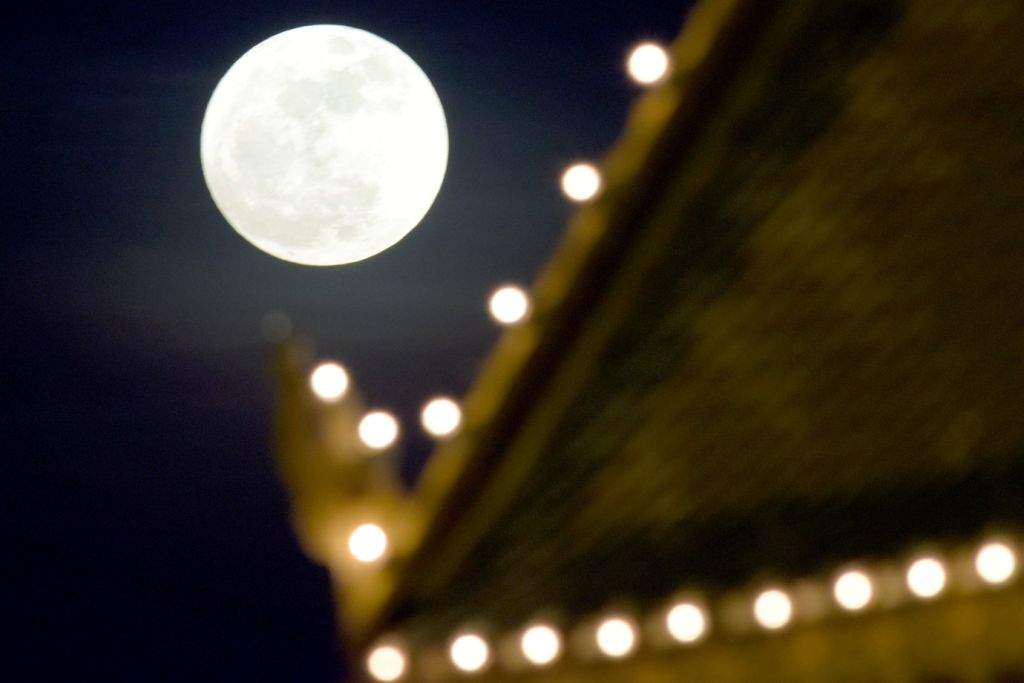 The 'supermoon' rises over a pagoda in front of the Royal Palace in Phnom Penh. (AFP PHOTO / TANG CHHIN SOTHY)