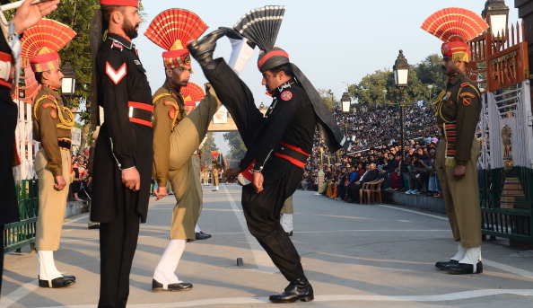 Pakistani Rangers (in Black) and Indian Border Security Force personnel (in Brown) perform the 'flag off' ceremony at the Pakistan-India Wagah Border Post on January 15, 2013. Indian Prime Minister Manmohan Singh warned Tuesday that there "cannot be business as usual" with neighbouring Pakistan after last week's deadly flare-up along the border in disputed Kashmir. AFP PHOTO/Arif ALI (Photo credit should read Arif Ali/AFP/Getty Images)