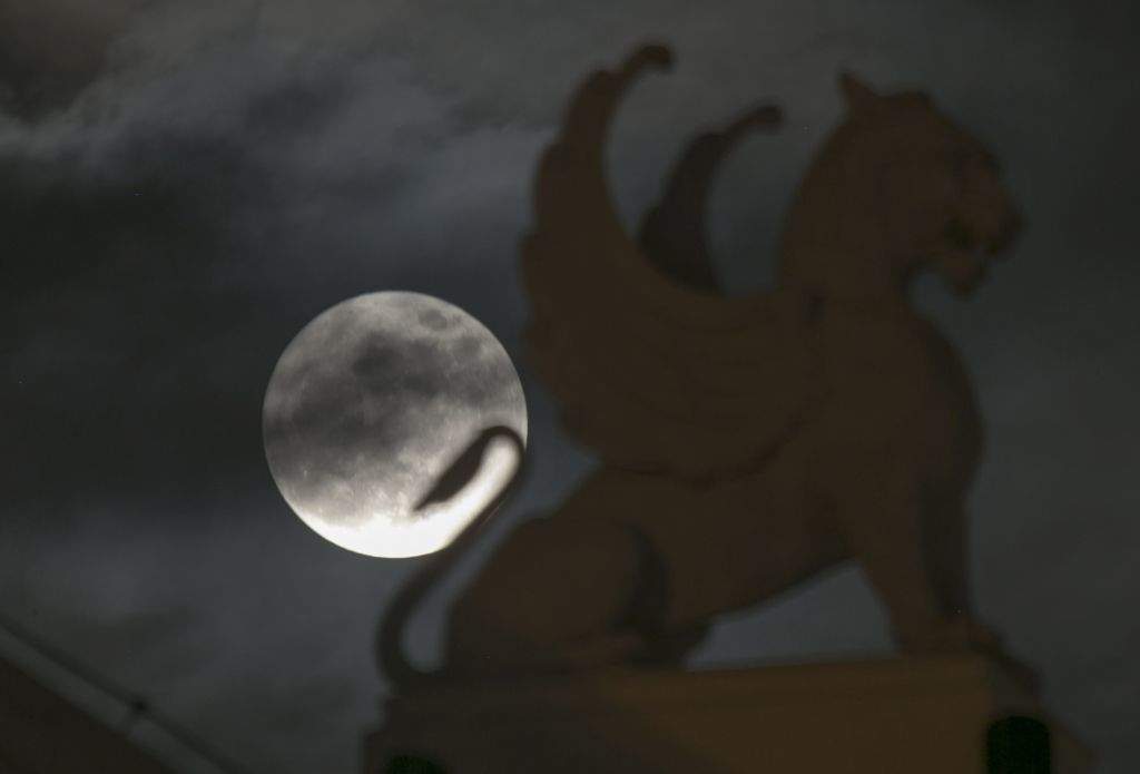 The supermoon appears behind a statue on the roof of the Opera House in Hanoi, Vietnam. (AP Photo/Hau Dinh)