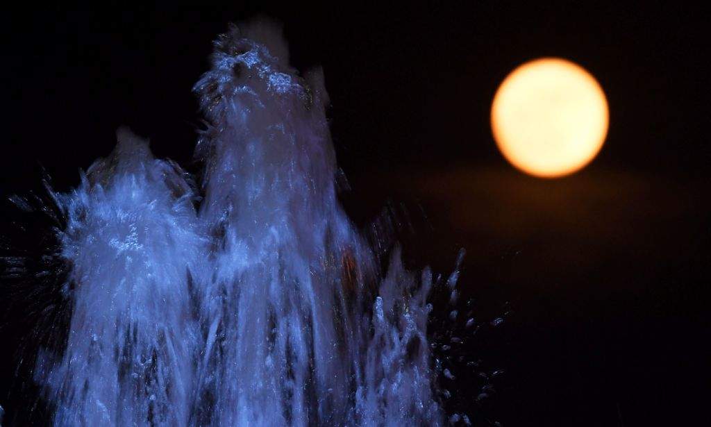 A 'supermoon rises in front of a water fountain in Kolkata. (AFP PHOTO / Dibyangshu SARKAR)