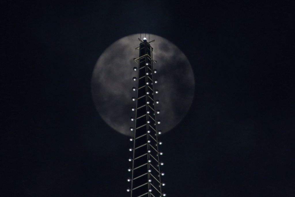 The supermoon is seen behind a building in Shanghai, China. (REUTERS/Aly Song)