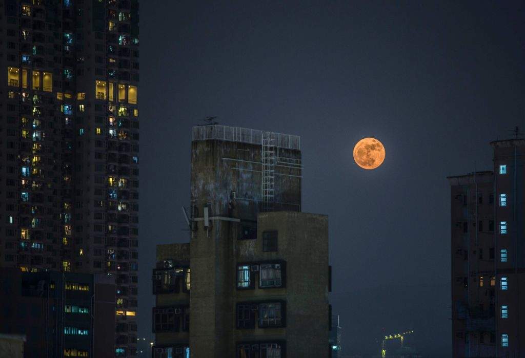 A 'supermoon' rises over residential buildings in the Kowloon district of Hong Kong. (AFP PHOTO / ISAAC LAWRENCE)