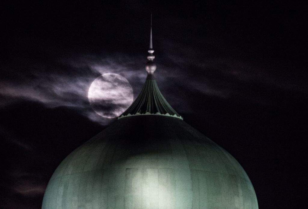 A 'supermoon' is seen past the dome of the Prime Minister's Office complex in Putrajaya. (AFP PHOTO / MOHD RASFAN)