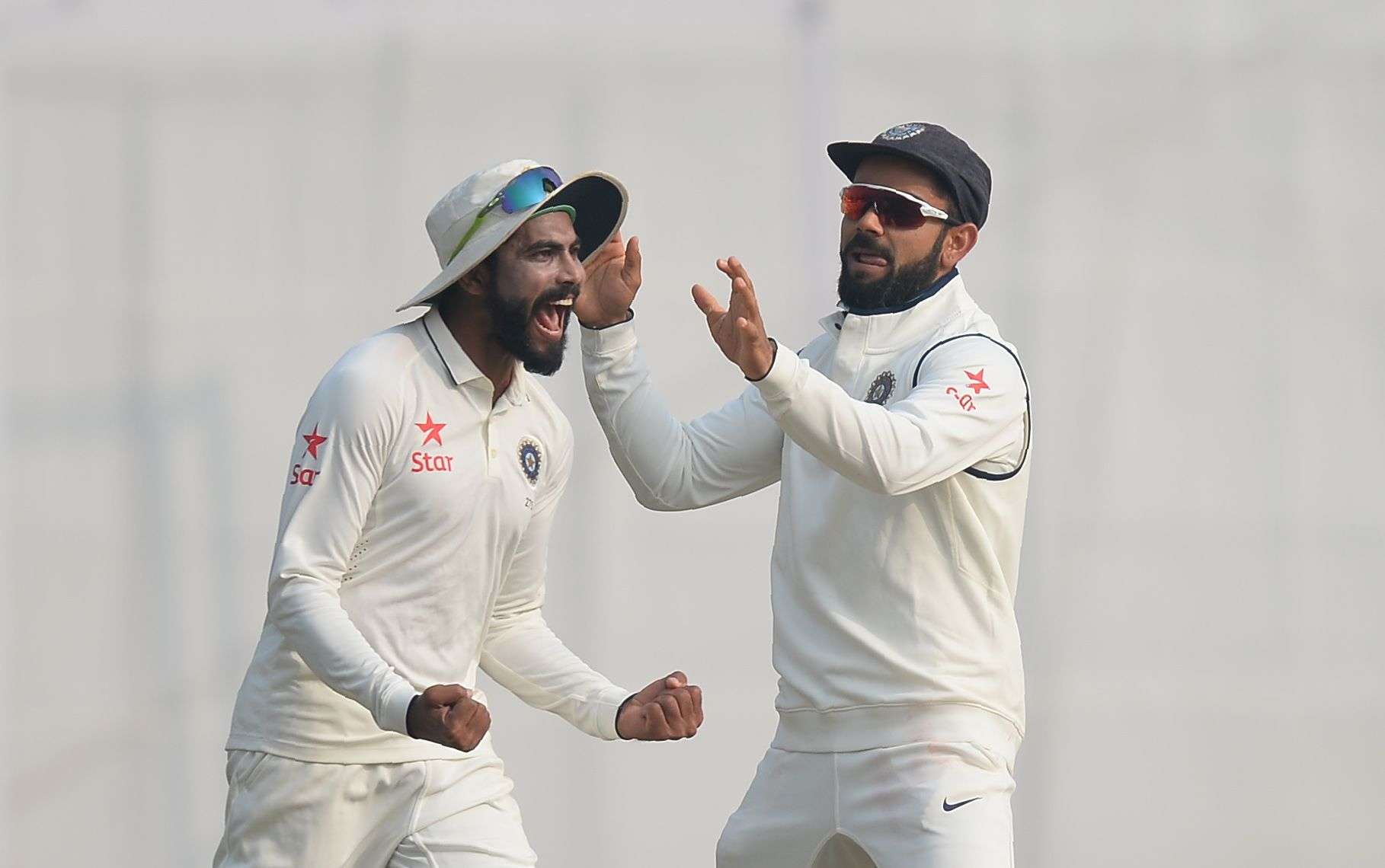 India cricketer Ravindra Jadeja (L) and captain Virat Kohli celebrate the dismissal of England batsman Jos Buttler on the fourth day of the third Test cricket match between India and England at The Punjab Cricket Association Stadium in Mohali on November 29, 2016. / AFP PHOTO / SAJJAD HUSSAIN / ----IMAGE RESTRICTED TO EDITORIAL USE - STRICTLY NO COMMERCIAL USE-----  GETTYOUT