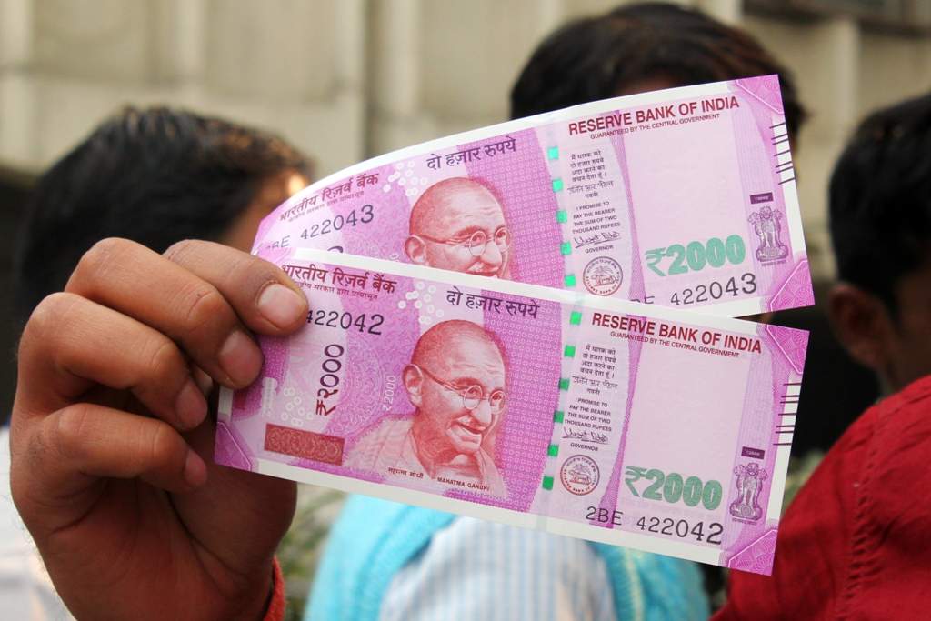 Show his new Rs 2000 notes at a bank in New Delhi on Thursday. PHOTO BY---VIPIN