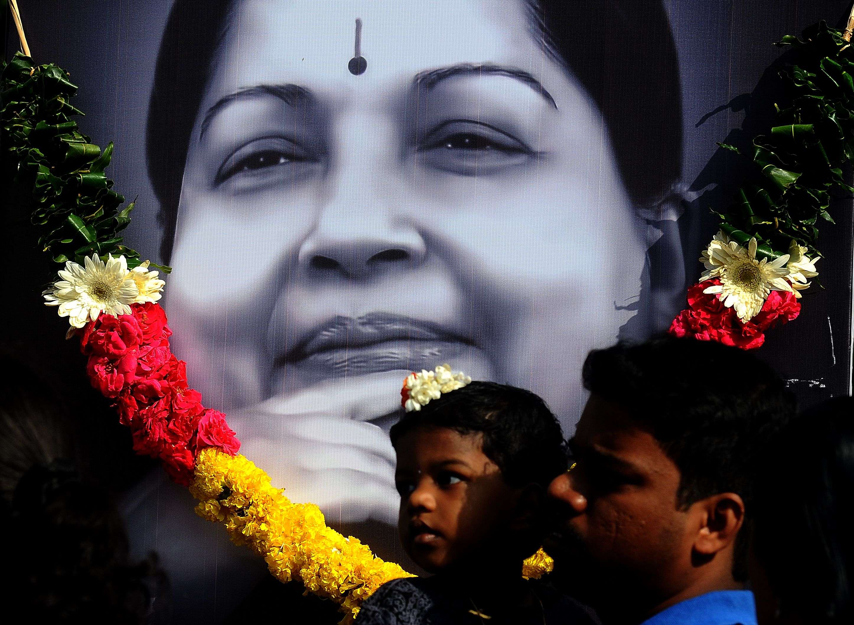Supporters of AIADMK pay homage to Former Chief Minister J Jayalalithaa in front of her picture outside MGR memorial on Kamarajar salai in Chennai on Wednesday 07-12-0216 Photo B A Raju