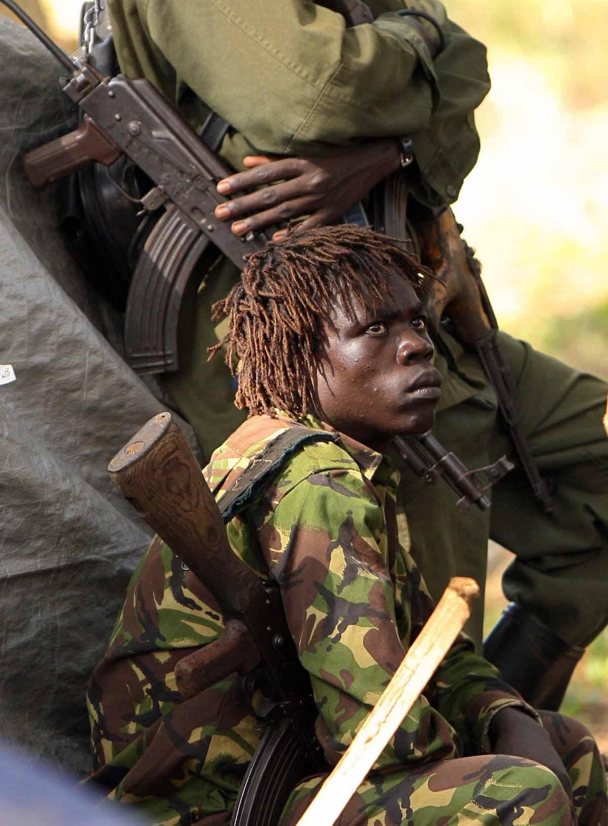 An armed fighter of the Lord's Resistance Army (LRA) looks at a fellow fighter 12 November 2006 during a meeting between the rebel group's leadership and United Nations Emergency Relief coordinator Jan Egeland in Ri-Kwamba, southern Sudan.