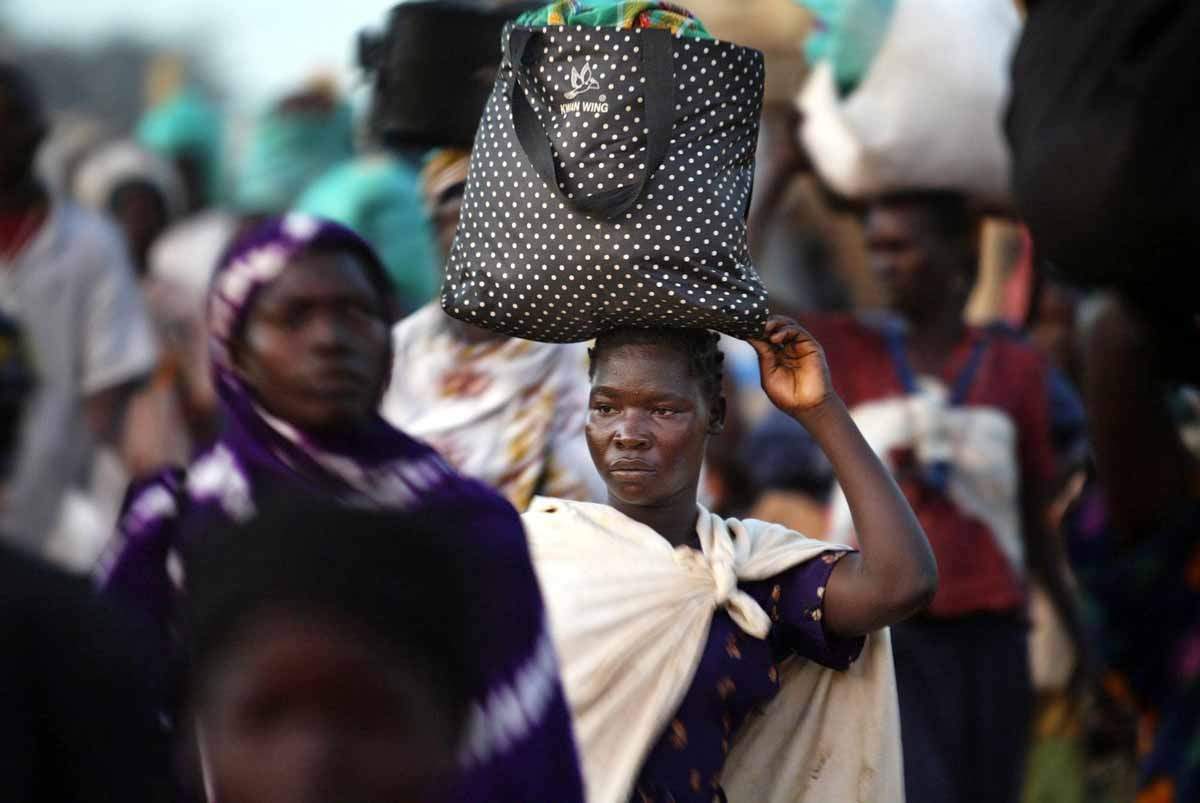 Residents return to their villages around the northern Ugandan town of Lira. Because of frequent raids on villages by the LRA, many residents come to Lira to spend the night, often on porches of shops. November, 2003. (AFP / Marco Longari)