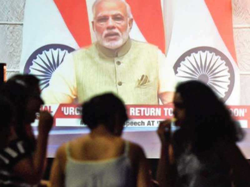 Youths tune into the Prime Minister’s speech at a Mumbai club. (PTI photo)