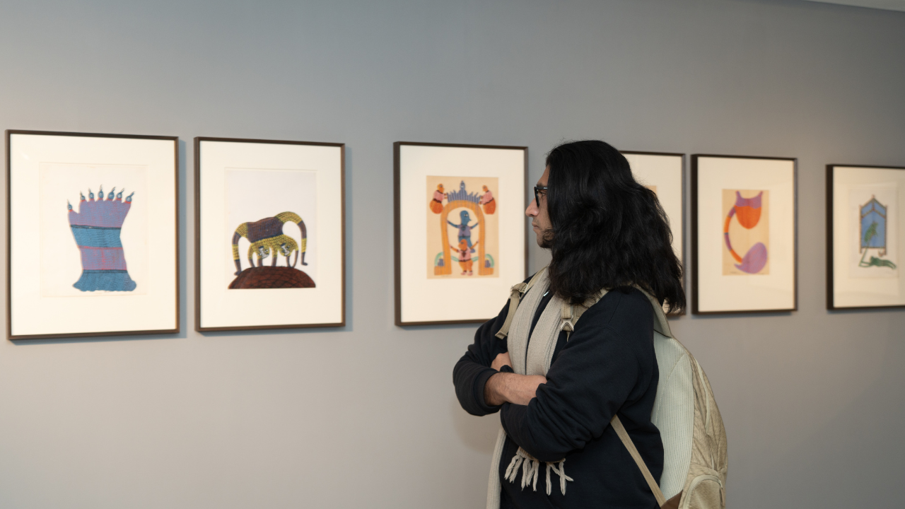 A visitor looks at Ram Singh Urveti&#39;s artworks