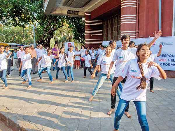 Students perform a street play outside Eros Theatre cstudents2