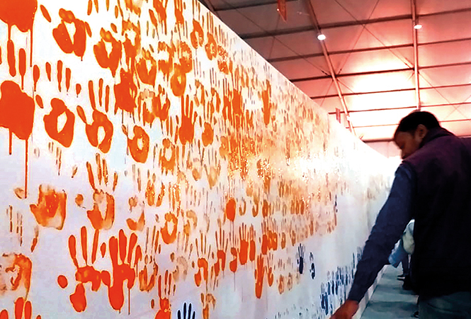 Devotees visiting the Kumbh put their hand prints on the painting (BCCL/ Pankaj Singh) Devotees visiting the Kumbh put their hand prints on the painting (BCCL/ Pankaj Singh)