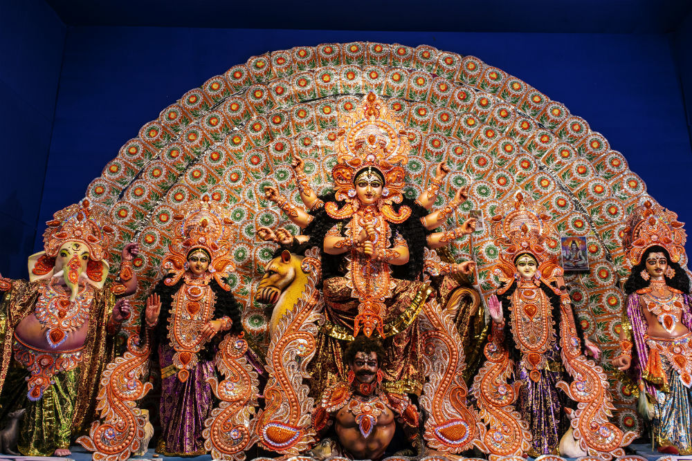 Happy Durga Puja Background. Goddess Durga idol at puja pandal, shot at  colored light at Kolkata. Biggest traditional religious festival of  Hinduism celebrated worldwide. Photos | Adobe Stock