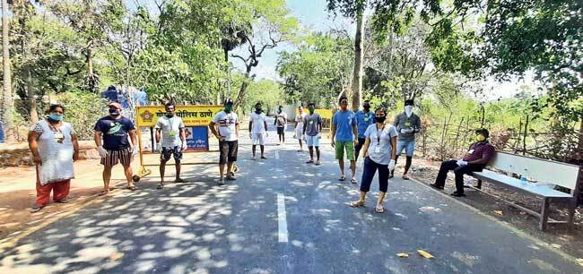 Volunteers help the police monitor the checkpost at the sole access road to the village