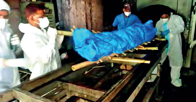 Hospital staff carry out last rites of an unclaimed body