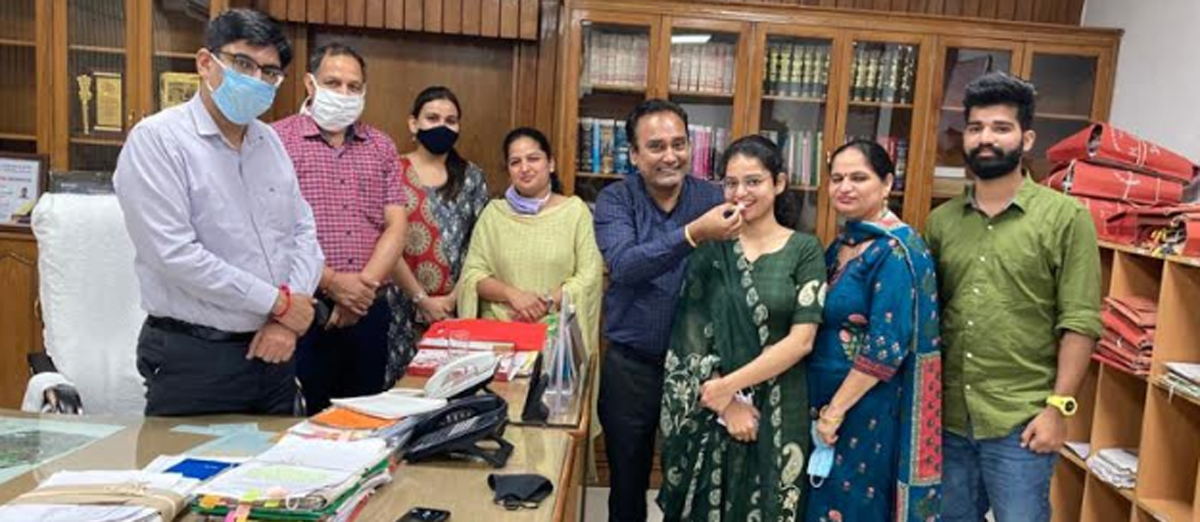 Mahak Swami (in green suit) celebrating achievement with her family at Yamunanagar deputy commissioner (DC) office on Tuesday.