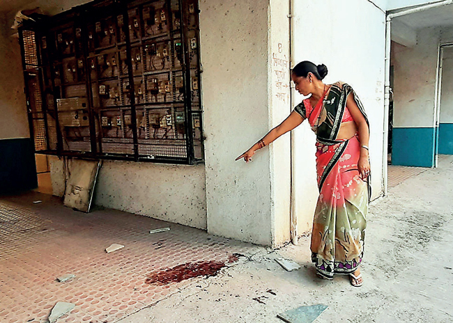 The guard at Siddhi Sankalp Society indicates where the victim was attacked and where she found him, lying in a pool of his own blood ; PIC: MAHENDRA KOLHE