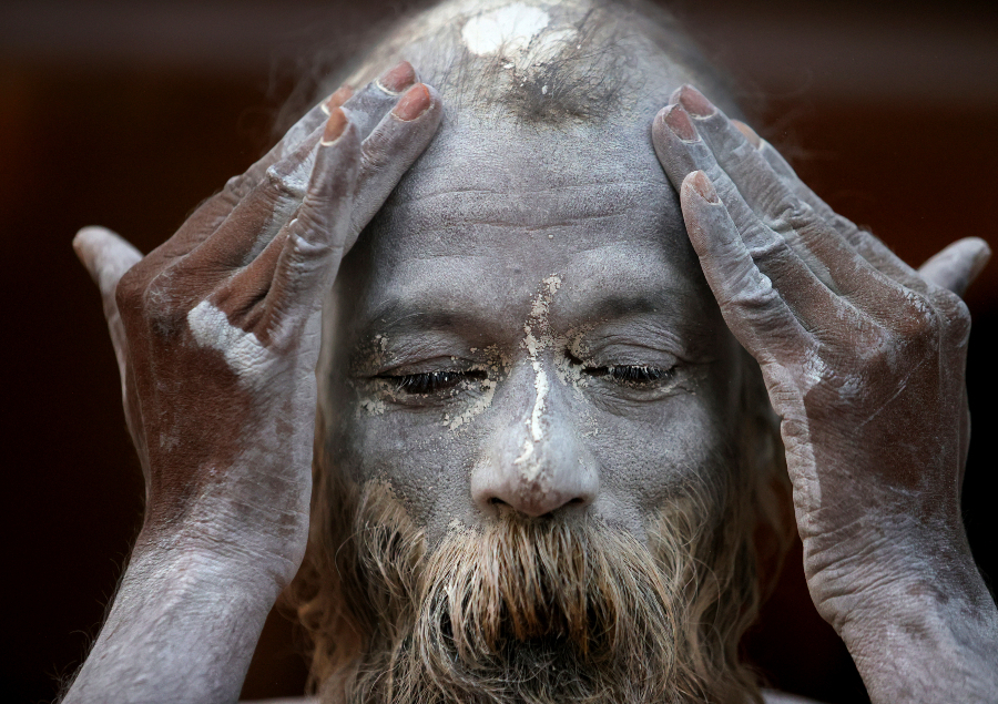 A Naga Sadhu rubes ash as he prepares to take holy dips in the river Ganges during Shahi snan AP635