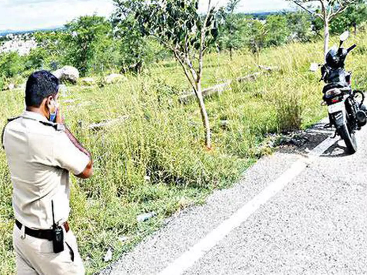 A police official inspects the crime scene near Chamundi Hills