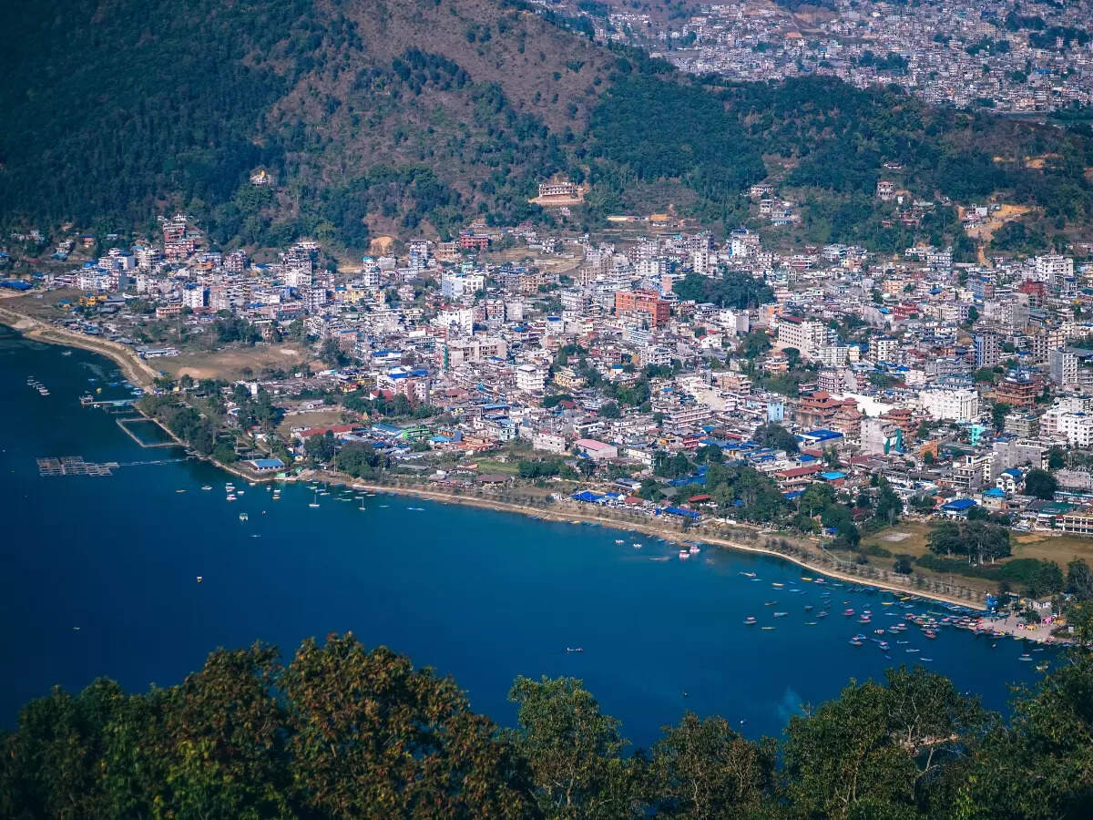 Wooden boats on Phewa Lake with snow peaks behind