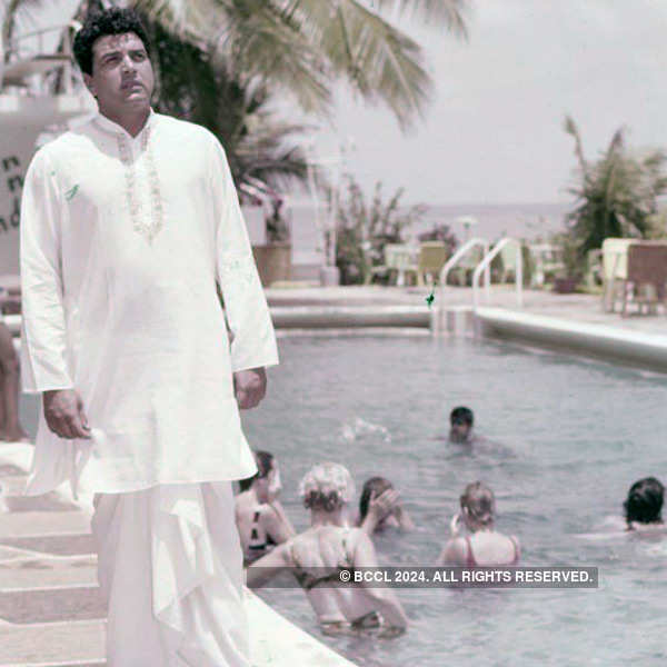 Clad in a white kurta and dhoti, Dharmendra roams around a swimming ...