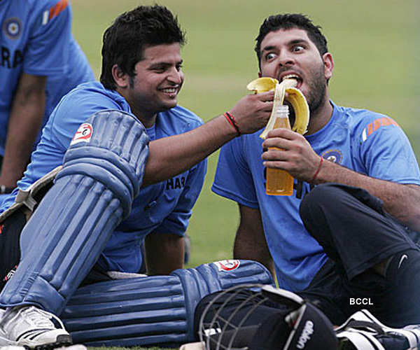 Yuvraj Singh devours a banana offered by his teammate Suresh Raina as they  share a light moment during play sessions on the field.