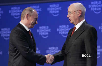 Russian Prime Minister Vladimir Putin, left, shakes hands with WEF ...