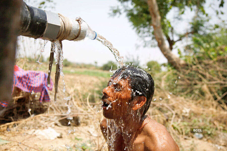An Indian man takes bath under the tap of a water tanker  Photogallery - Times of India