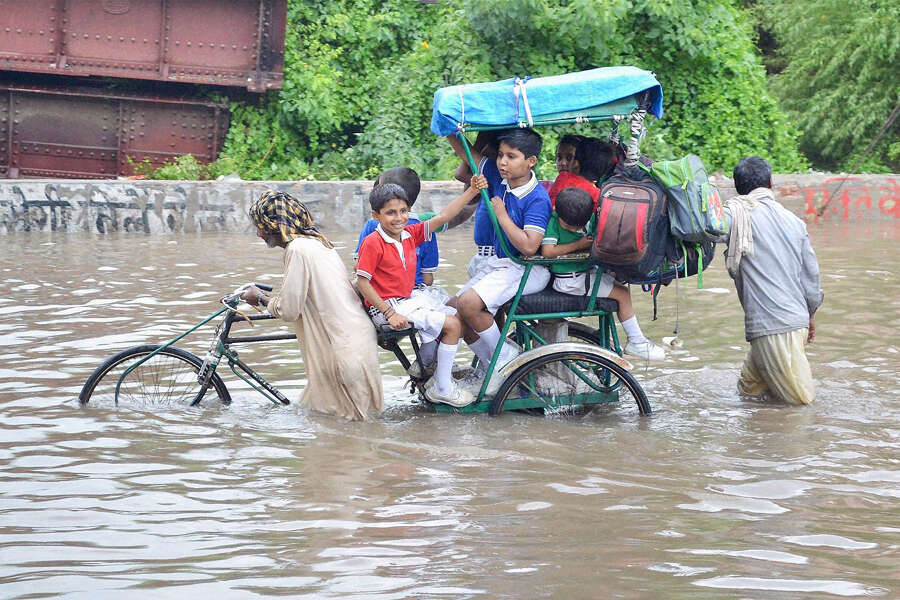 School children move through a flooded street